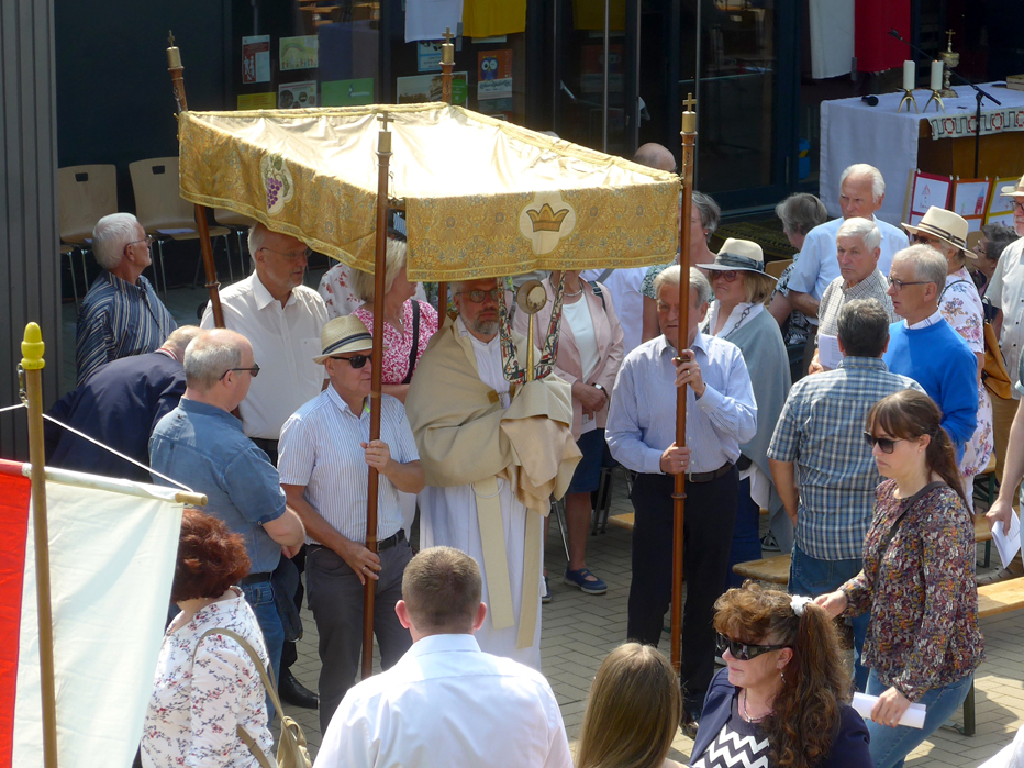 Pfarrer mit Monstranz unter Baldachim