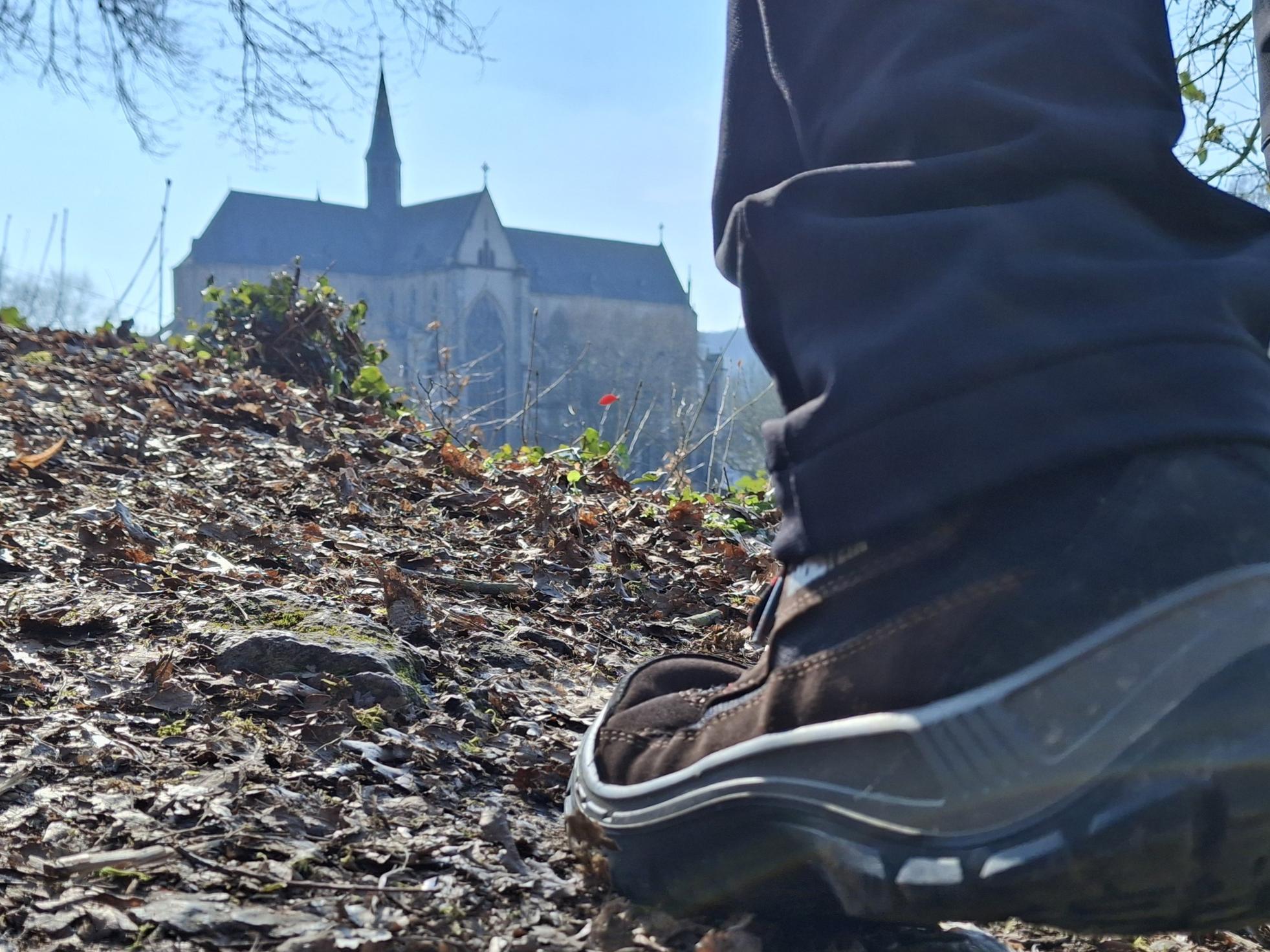 Altenberger Dom im Hintergrund - im Vordergrund großer Wanderschuh