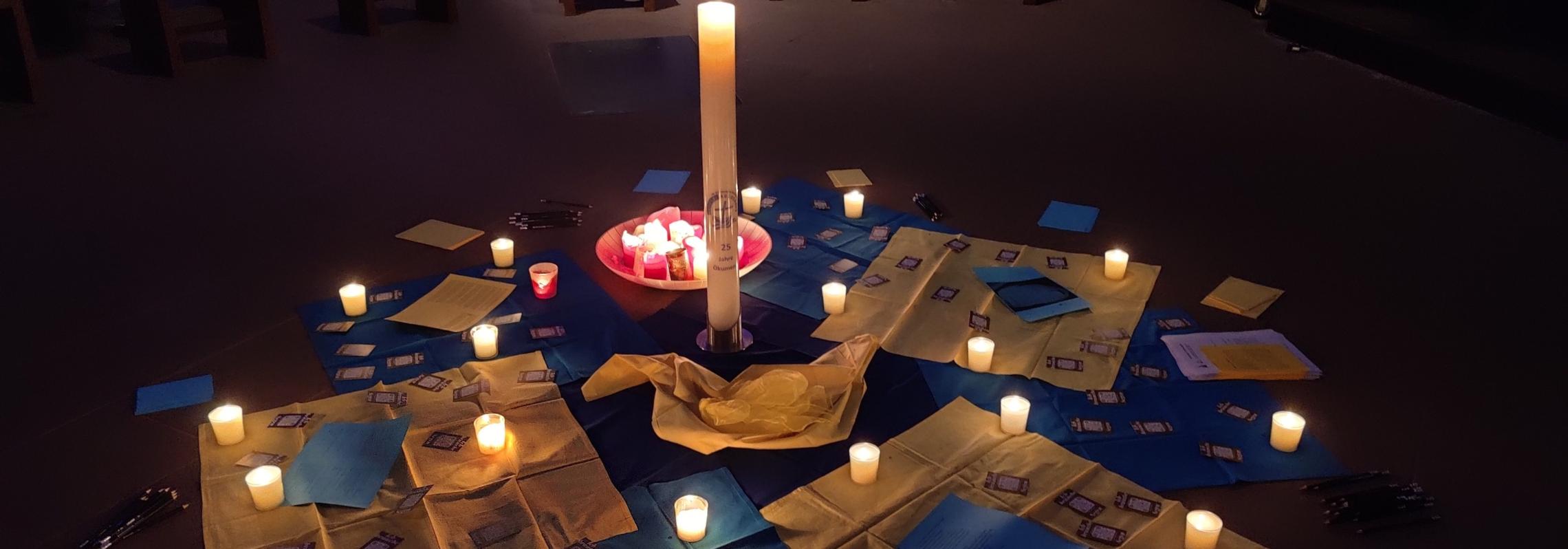 Eine gestaltete MItte mit Kerzen, Tüchern und Karten