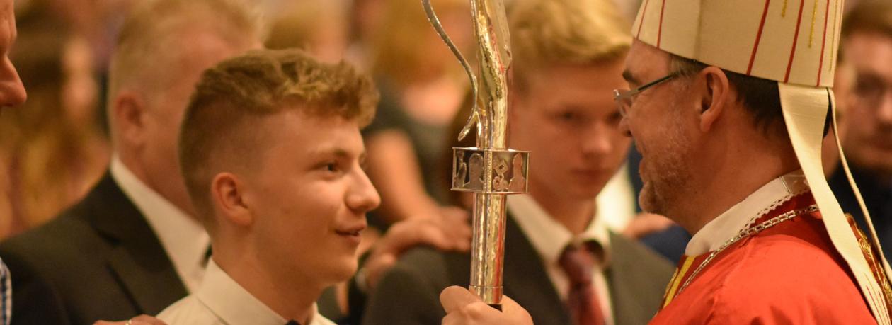 Bischof firmt einen Jugendlichen